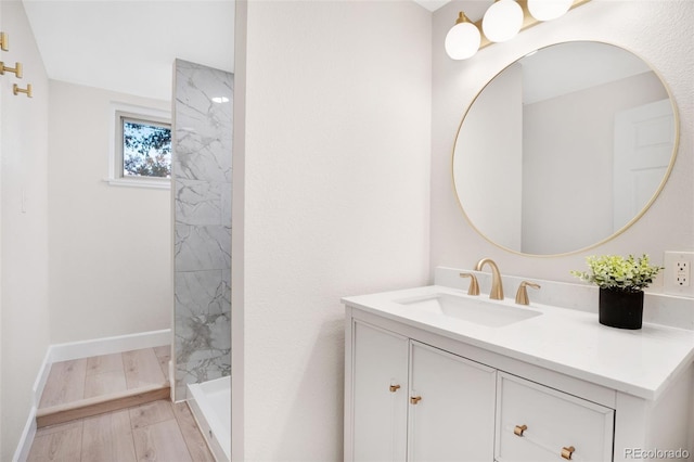 bathroom featuring hardwood / wood-style floors, vanity, and a tile shower