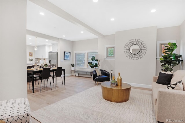 living room with light hardwood / wood-style floors and beamed ceiling