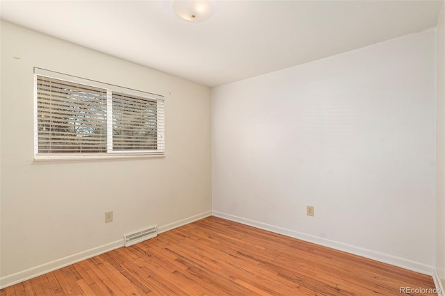 empty room featuring visible vents, baseboards, and light wood-style flooring