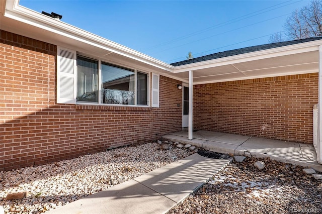 doorway to property featuring brick siding