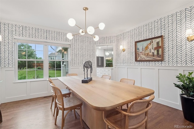 3566 E Meadow Creek Pl, Highlands Ranch, CO 80126 - dining room featuring wallpapered walls, a decorative wall, a chandelier, wood finished floors, and ornamental molding