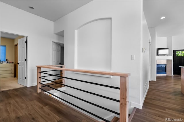 corridor featuring an upstairs landing, wood finished floors, baseboards, and recessed lighting