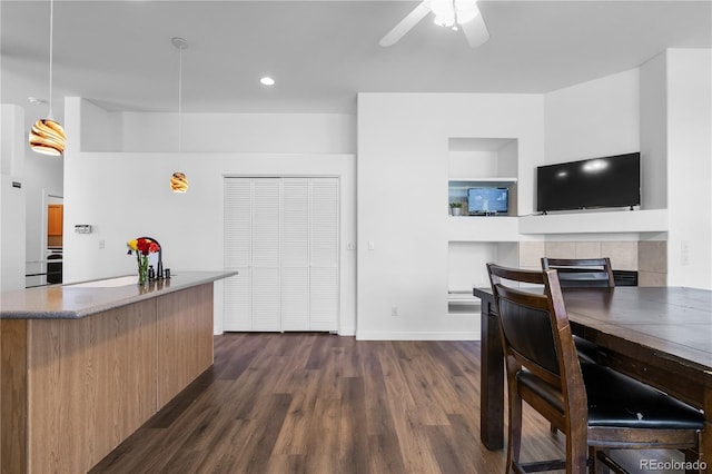 kitchen with dark wood finished floors, ceiling fan, modern cabinets, decorative light fixtures, and baseboards