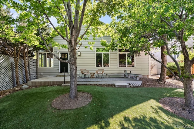 back of house featuring a yard and a wooden deck