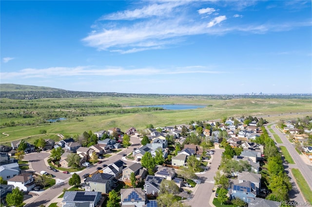 aerial view of property and surrounding area with a nearby body of water and nearby suburban area