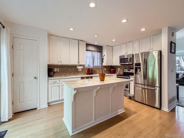 426 N 48th Ave, Brighton, CO 80601 - kitchen with appliances with stainless steel finishes, a center island, light wood-style floors, white cabinets, and recessed lighting
