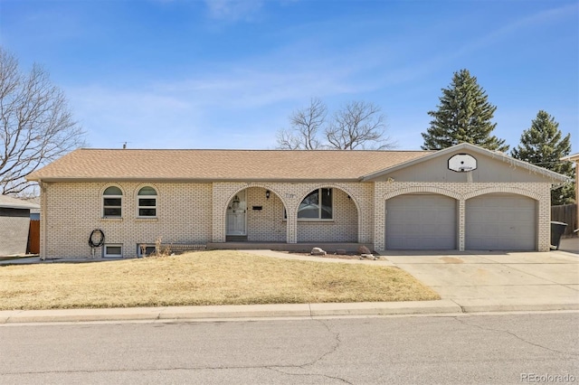 view of front of house featuring roof with shingles, an attached garage, concrete driveway, a front lawn, and brick siding