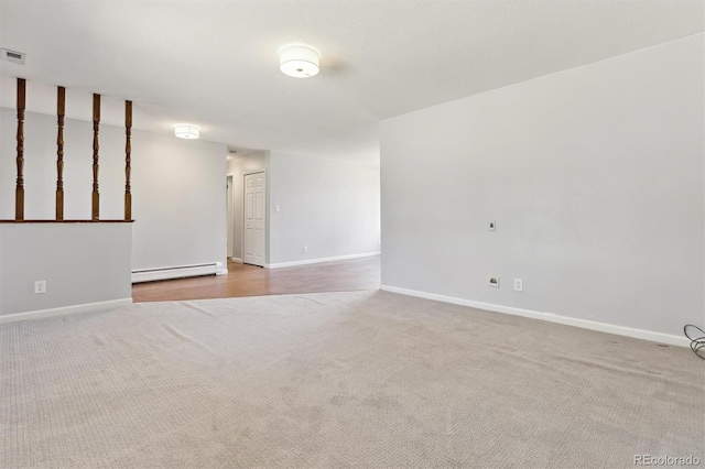 spare room featuring visible vents, carpet floors, baseboard heating, and baseboards