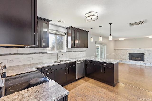 kitchen featuring visible vents, dishwasher, electric range oven, a peninsula, and a sink