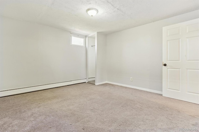 spare room with baseboards, carpet floors, baseboard heating, and a textured ceiling