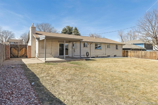 back of property featuring a patio area, a fenced backyard, a yard, and brick siding