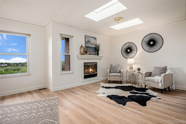 44 S Holman Way, Golden, CO 80401 - sitting room with a skylight, wood finished floors, a glass covered fireplace, a textured ceiling, and baseboards