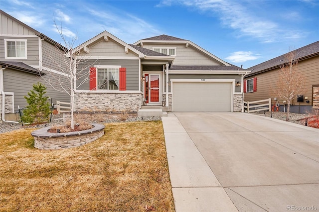 craftsman-style house featuring a garage, a shingled roof, driveway, stone siding, and a front yard