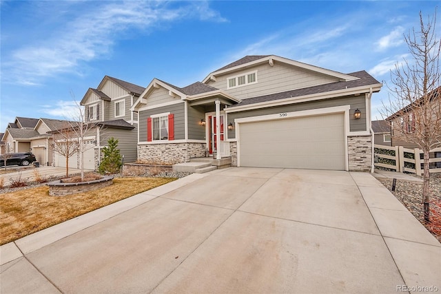 craftsman-style home featuring roof with shingles, an attached garage, fence, stone siding, and driveway