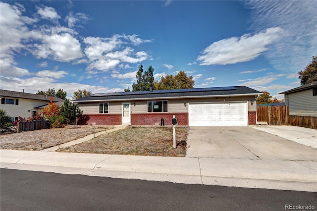 ranch-style home featuring solar panels and a garage