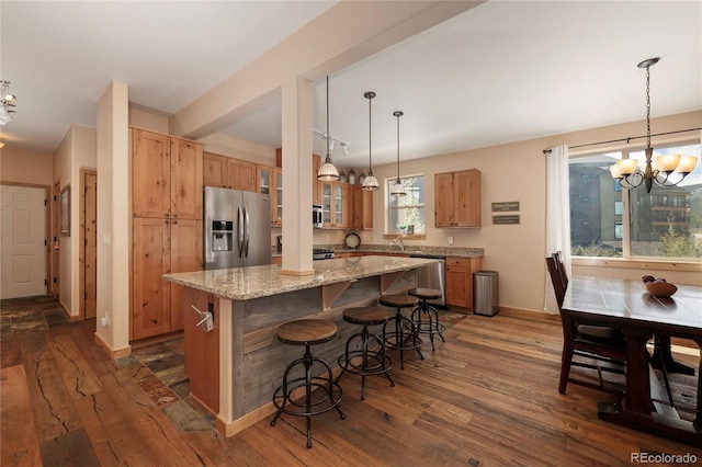 301 Trailhead Cir Unit 324, Winter Park, CO 80482 - kitchen featuring stainless steel appliances, dark wood-type flooring, a kitchen island, a chandelier, and a breakfast bar