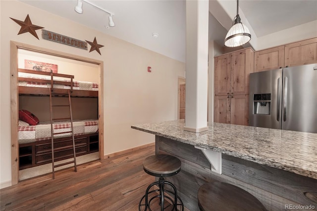301 Trailhead Cir Unit 324, Winter Park, CO 80482 - kitchen featuring stainless steel fridge with ice dispenser, dark wood finished floors, light stone counters, a breakfast bar area, and light brown cabinets