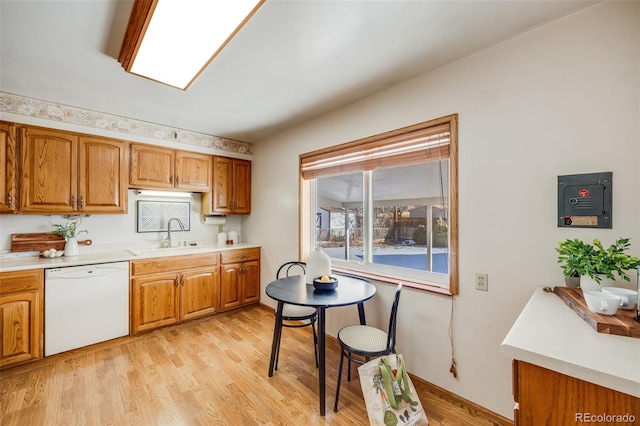 kitchen with white dishwasher, sink, and light wood-type flooring