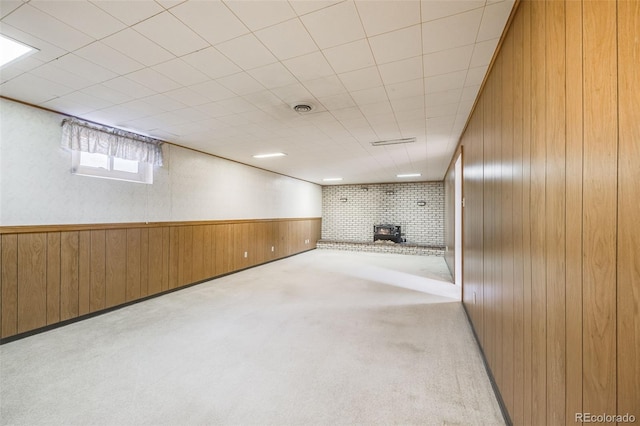 basement with light carpet and wood walls