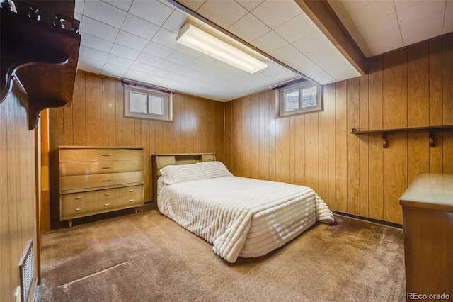 bedroom featuring multiple windows, wooden walls, and dark carpet