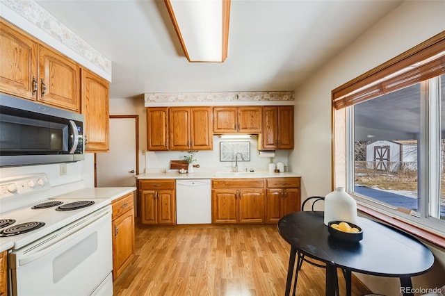 kitchen featuring sink, white appliances, and light hardwood / wood-style flooring