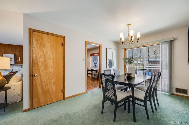 carpeted dining space featuring a chandelier