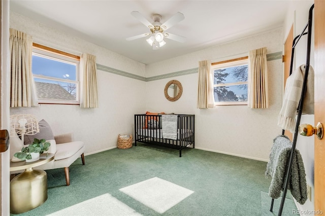 bedroom featuring ceiling fan, carpet flooring, multiple windows, and a crib