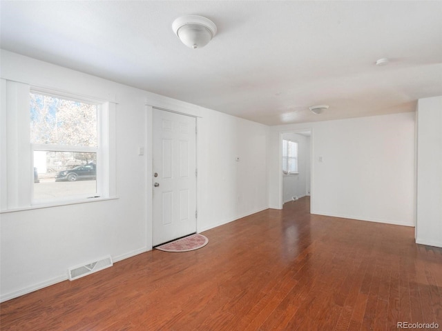 spare room with dark hardwood / wood-style floors and a wealth of natural light