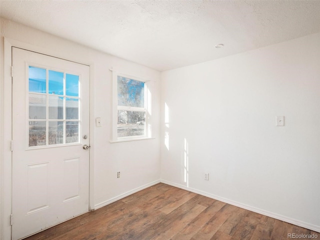 doorway with hardwood / wood-style floors and a textured ceiling