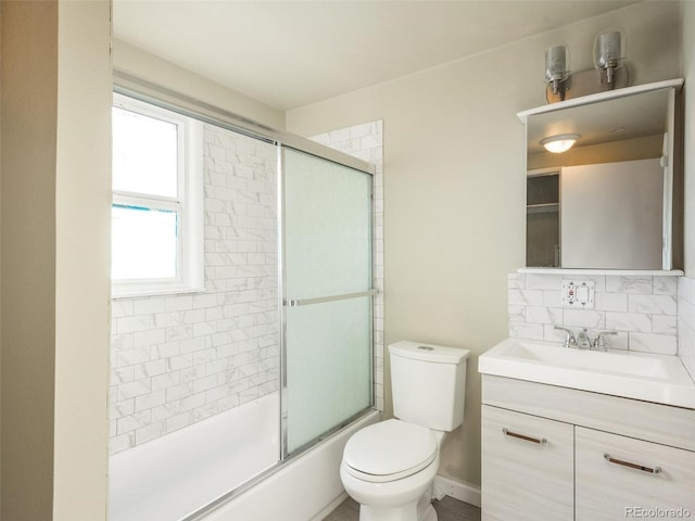 full bathroom featuring vanity, toilet, shower / bath combination with glass door, and tasteful backsplash