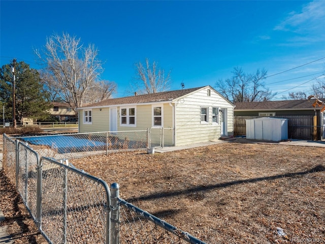 rear view of property featuring a storage shed