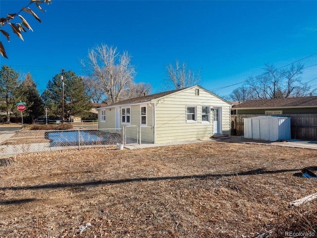 rear view of property featuring a shed