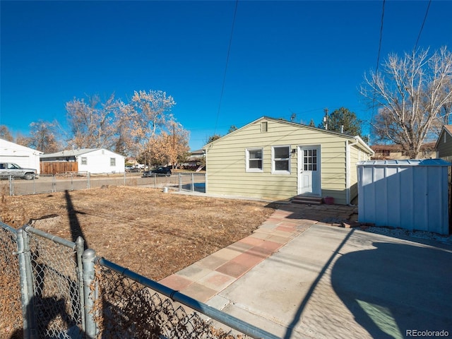 rear view of house featuring a patio area and a shed