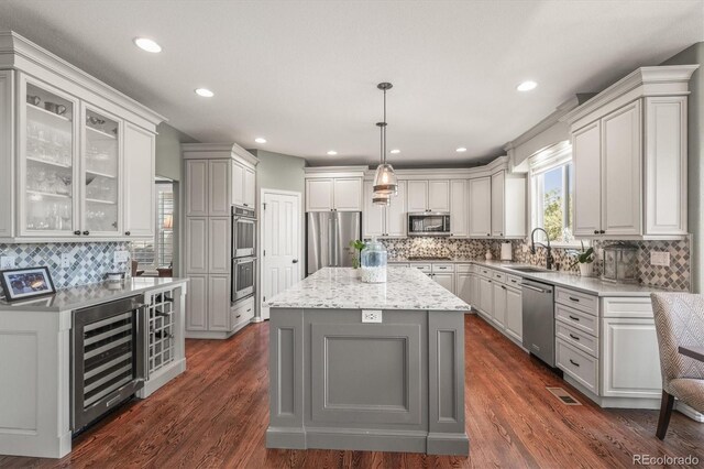 kitchen featuring beverage cooler, a sink, appliances with stainless steel finishes, and tasteful backsplash