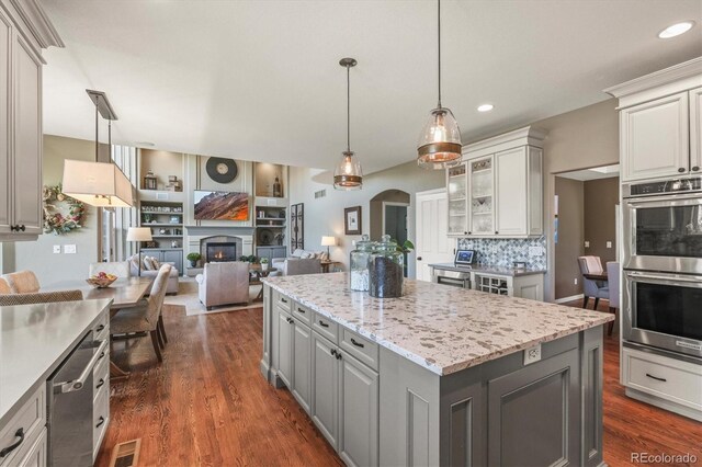 kitchen featuring gray cabinets, visible vents, appliances with stainless steel finishes, a center island, and open floor plan