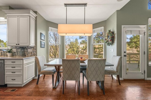 dining area featuring visible vents, plenty of natural light, and dark wood-type flooring