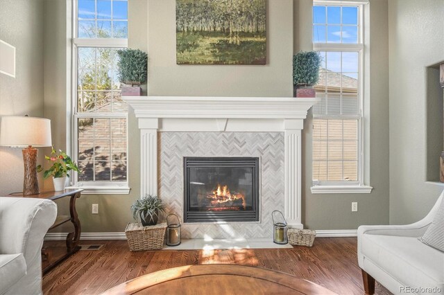 living area featuring baseboards, a fireplace, and wood finished floors