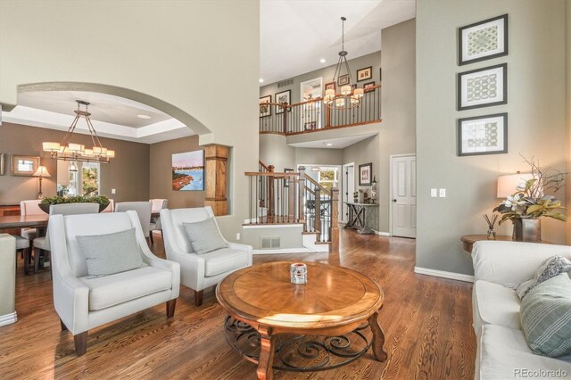 living room with stairs, baseboards, and a notable chandelier