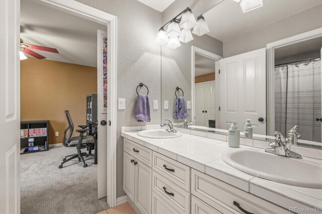 bathroom featuring double vanity, ceiling fan, and a sink
