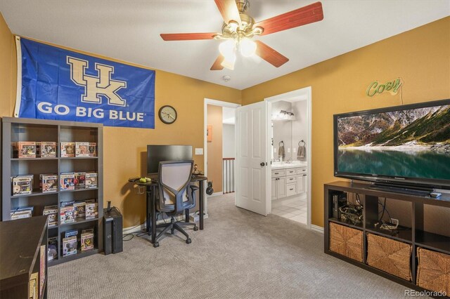 carpeted office with baseboards and a ceiling fan