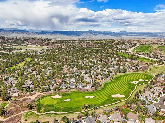 drone / aerial view featuring view of golf course, a residential view, and a mountain view
