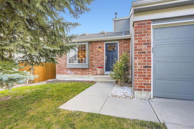 12476 W Prentice Pl, Littleton, CO 80127 - view of exterior entry with brick siding and an attached garage