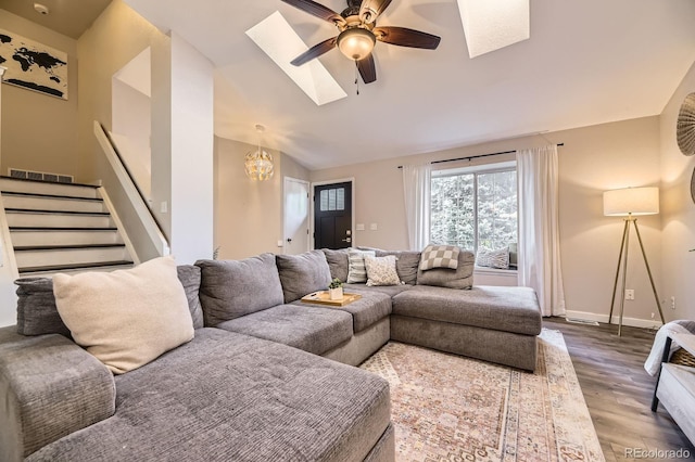 12476 W Prentice Pl, Littleton, CO 80127 - living area featuring a skylight, wood finished floors, lofted ceiling, a ceiling fan, and stairs