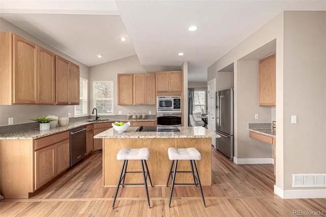 16434 Homestead Ct, Parker, CO 80134 - kitchen with a center island, a sink, light wood-type flooring, stainless steel appliances, and visible vents