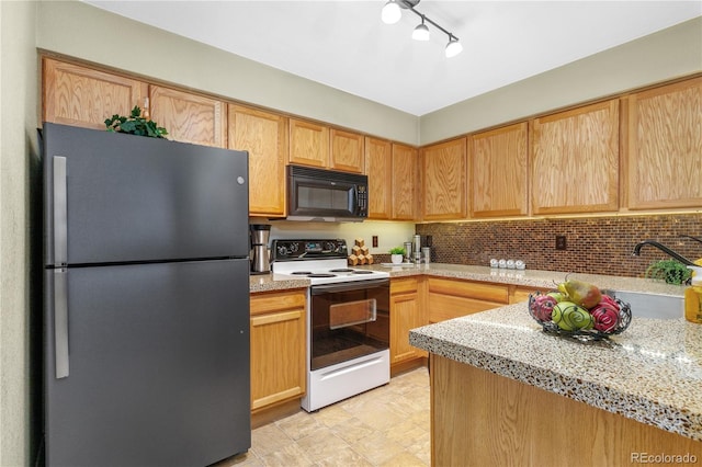 kitchen with freestanding refrigerator, electric stove, tasteful backsplash, and black microwave