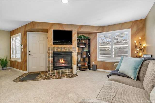 carpeted living area with baseboards and a tiled fireplace