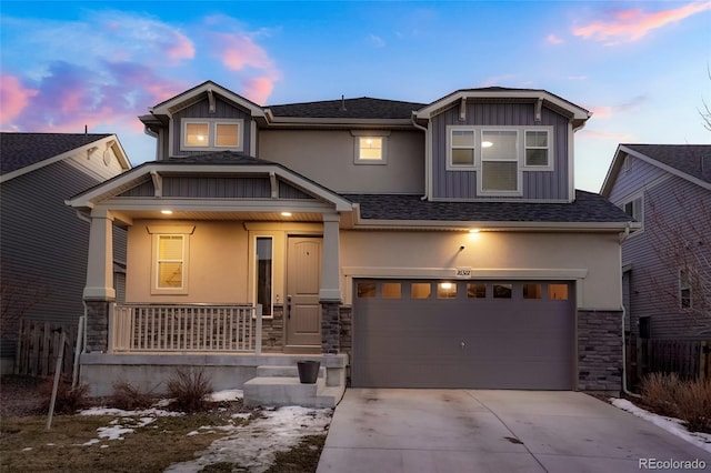 craftsman house featuring covered porch, a garage, stone siding, driveway, and stucco siding