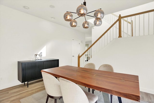 11575 Wilson Cir, Parker, CO 80134 - dining area featuring light wood-style flooring, a chandelier, and stairs