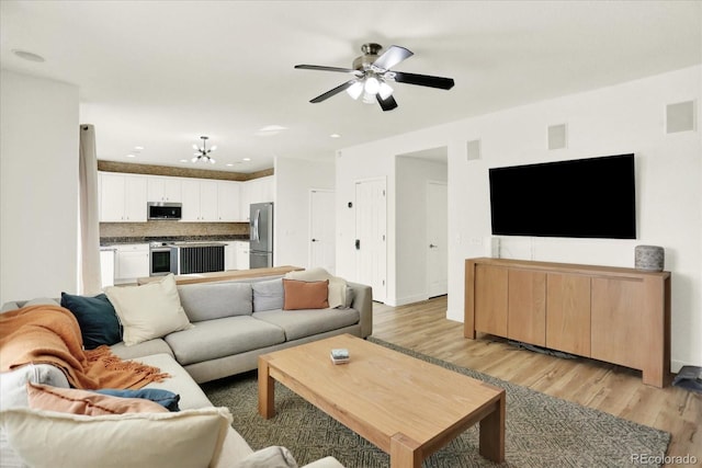11575 Wilson Cir, Parker, CO 80134 - living area featuring light wood finished floors, a chandelier, and ceiling fan