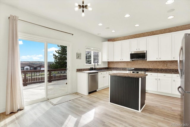 11575 Wilson Cir, Parker, CO 80134 - kitchen with appliances with stainless steel finishes, white cabinets, backsplash, a kitchen island, and recessed lighting